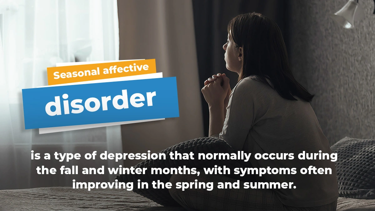 Woman on a bed looking out a window in a dark room. White text explains that seasonal affective disorder (SAD) is a type of depression.