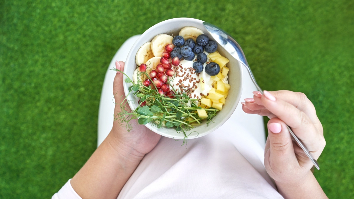 women holding a bowl of balanced fruits and vegetables