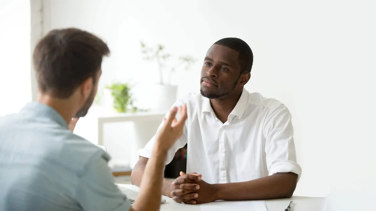 Employee having a private conversation with their manager about seeking rehabilitation.