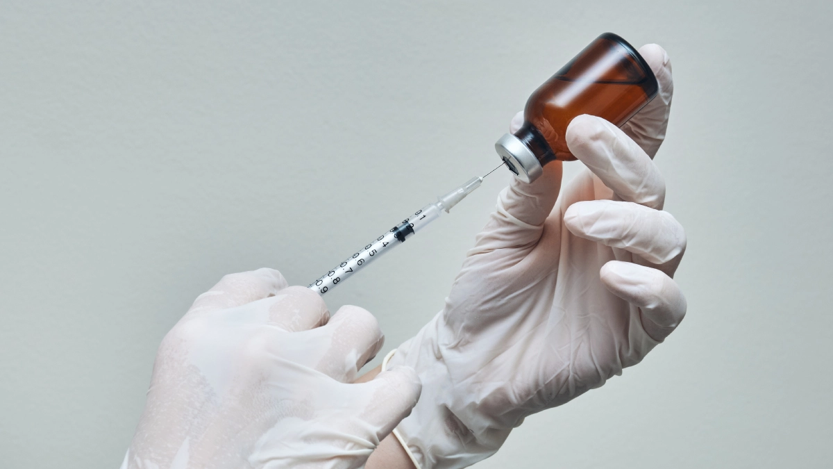 a syringe being injected into a ketamine bottle