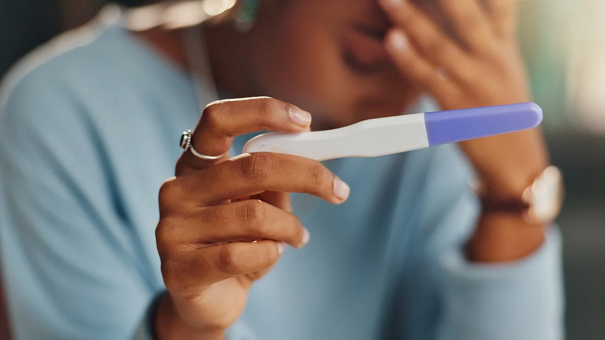 woman holding a pregnancy test